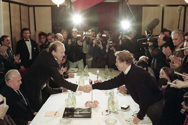 První setkání a jednání představitelů vlády se zástupci OF v Obecním domě 26. listopadu 1989. Ruce si podali i Marián Čalfa a Václav Havel.